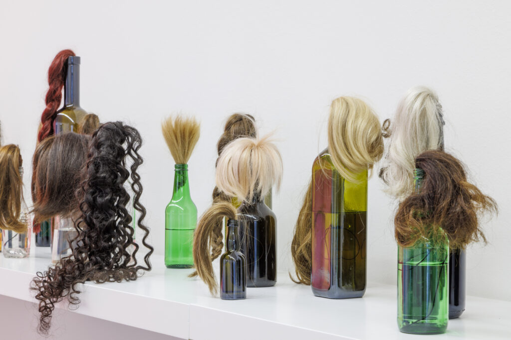 Isabelle Krieg, "Hair Cocktails", 2023, Frauenhaar, Flaschen, Schnur, Brennsprit, destilliertes Wasser, Grösse variabel © F.X. Brun